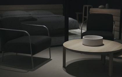 A close-up of a modern living room with chairs and a round coffee table.